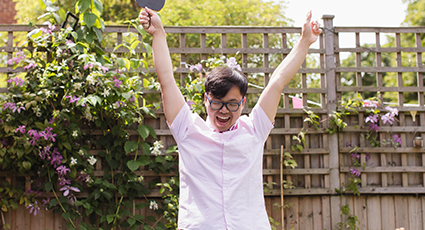 Young east asian man with glasses, celebrating winning at table tennis.