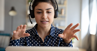 Woman using headset looking at laptop